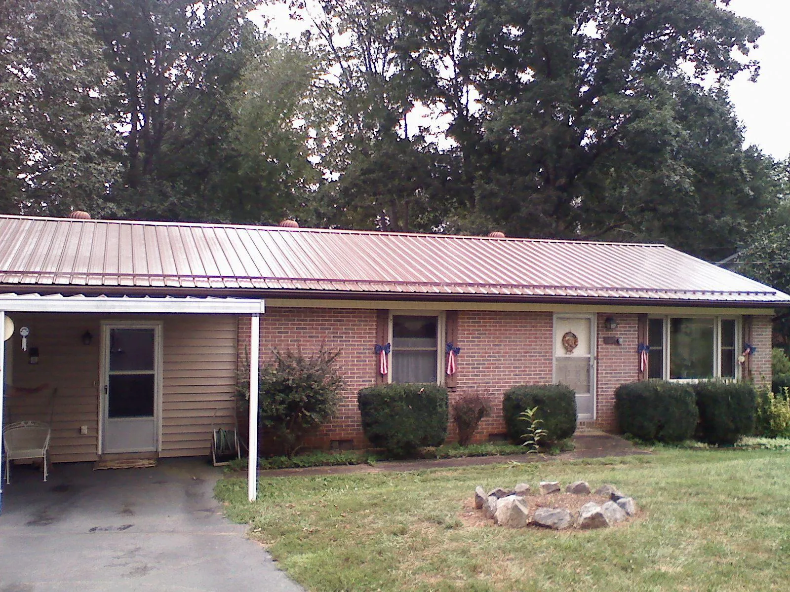 Bronze metal roof and carport on a brick ranch home — Roof Repair work by our crew in Malmo